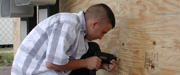 Graphic Showing a man screwing down plywood  